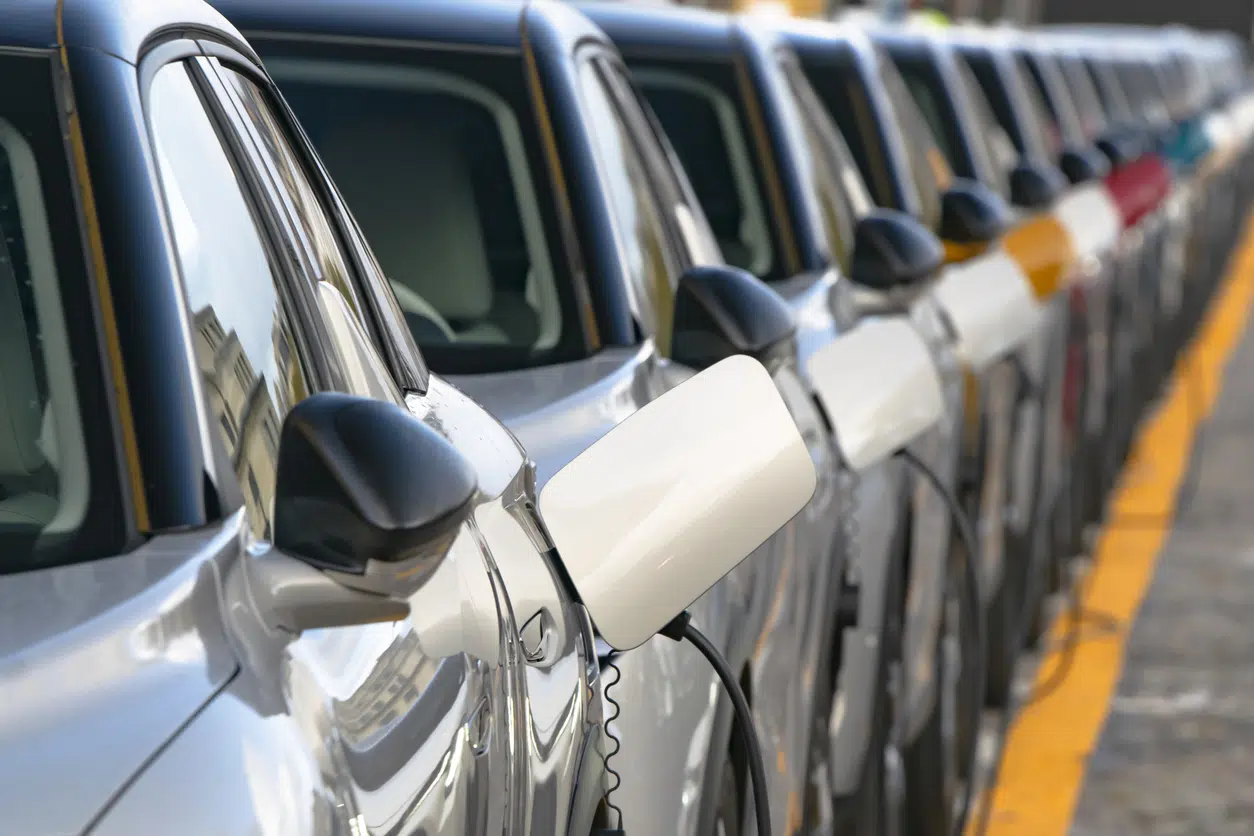Electric vehicles at charging points in line on street image