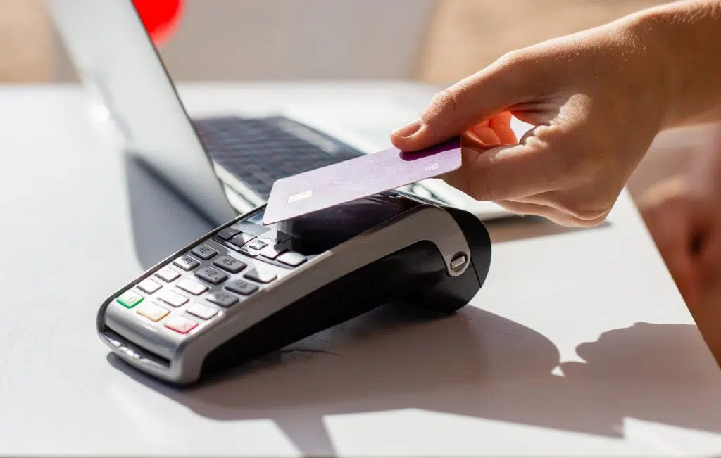Person, die Karte für kontaktloses Bezahlen an Automaten verwendet