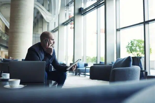 man on mobile phone sitting in office reception area image