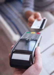 Person, die mit Kreditkarte an einem POS-Terminal bezahlt (Bild)