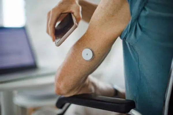 person using phone to check monitor on arm image