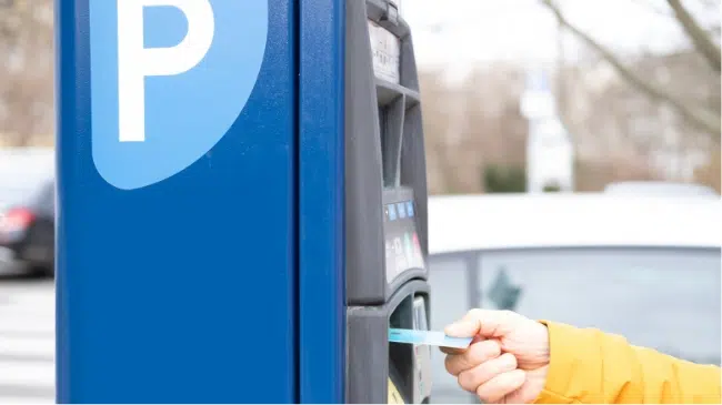 person paying with card at parking machine image