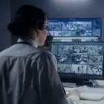 woman on headset monitoring CCTV image