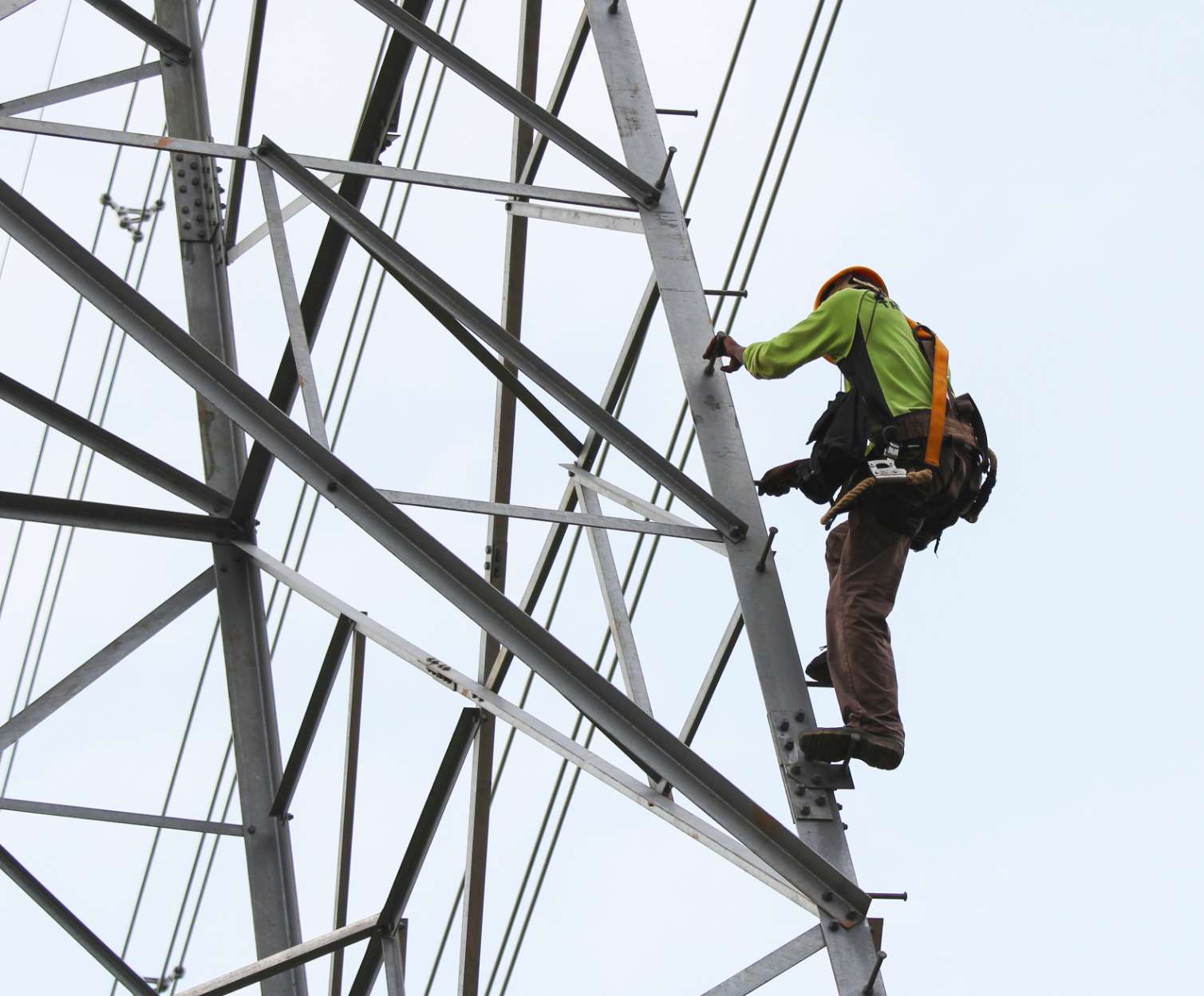 workman climbing utilities tower image