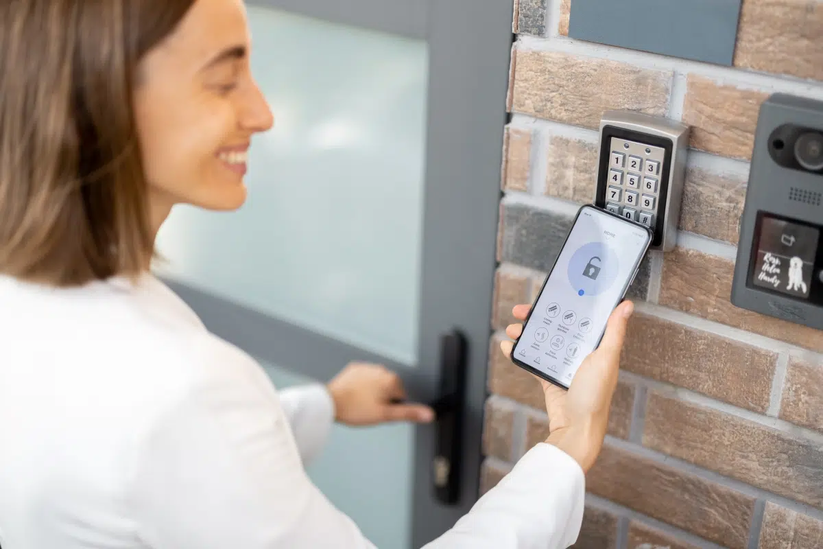 woman using mobile phone to unlock smart door image