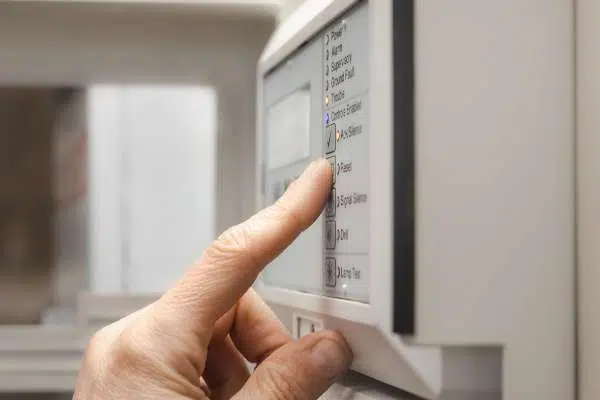 hand pressing button on security alarm image