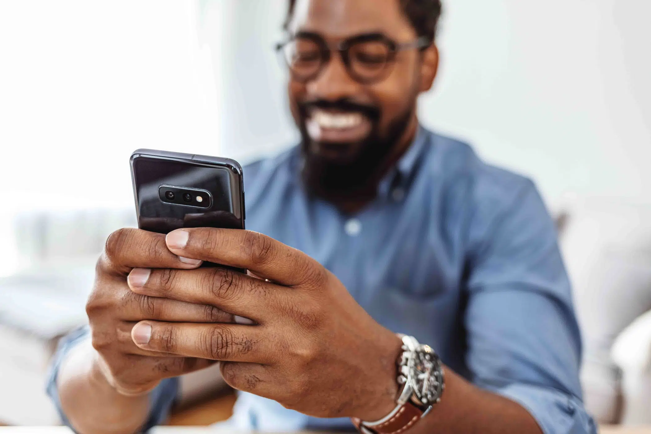 smiling man sitting looking at phone image