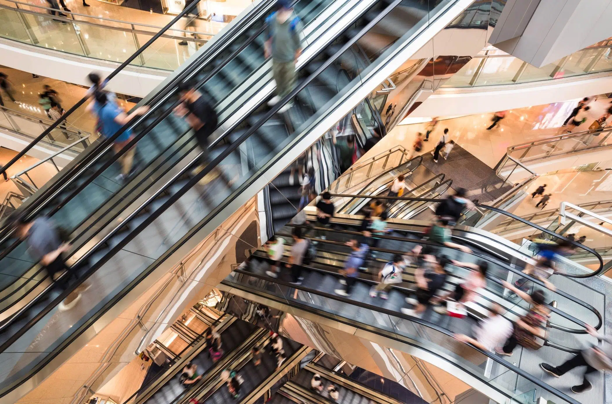 multiple escalators in shopping centre blurred image