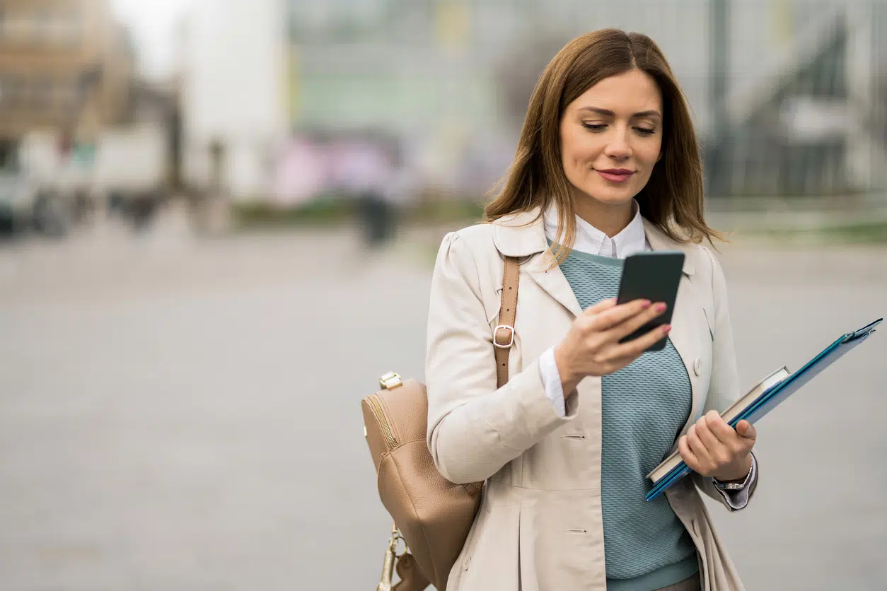 Young businesswoman using phone on city street image