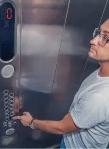Man pressing button in lift image
