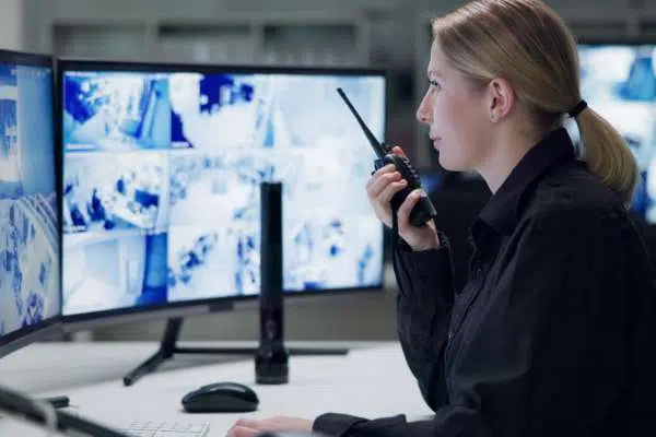 woman on radio comms monitoring CCTV on multiple screens image