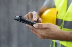 workman with hi-vis and hardhat on mobile phone image