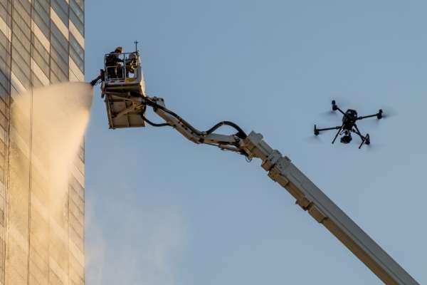 fire fighters spraying water on skyscraper in crane and drone image