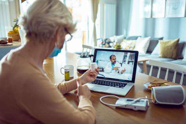 patient at home on laptop to doctor image