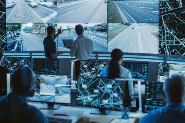 people in monitoring centre with multiple screens image