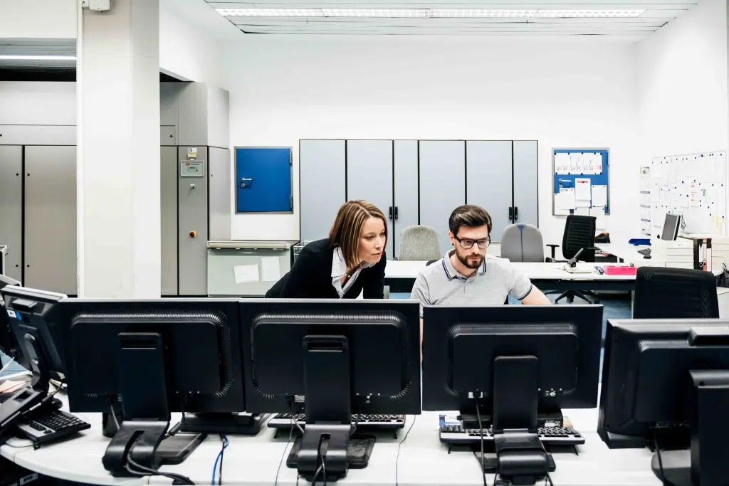people working with lots of computer screens image
