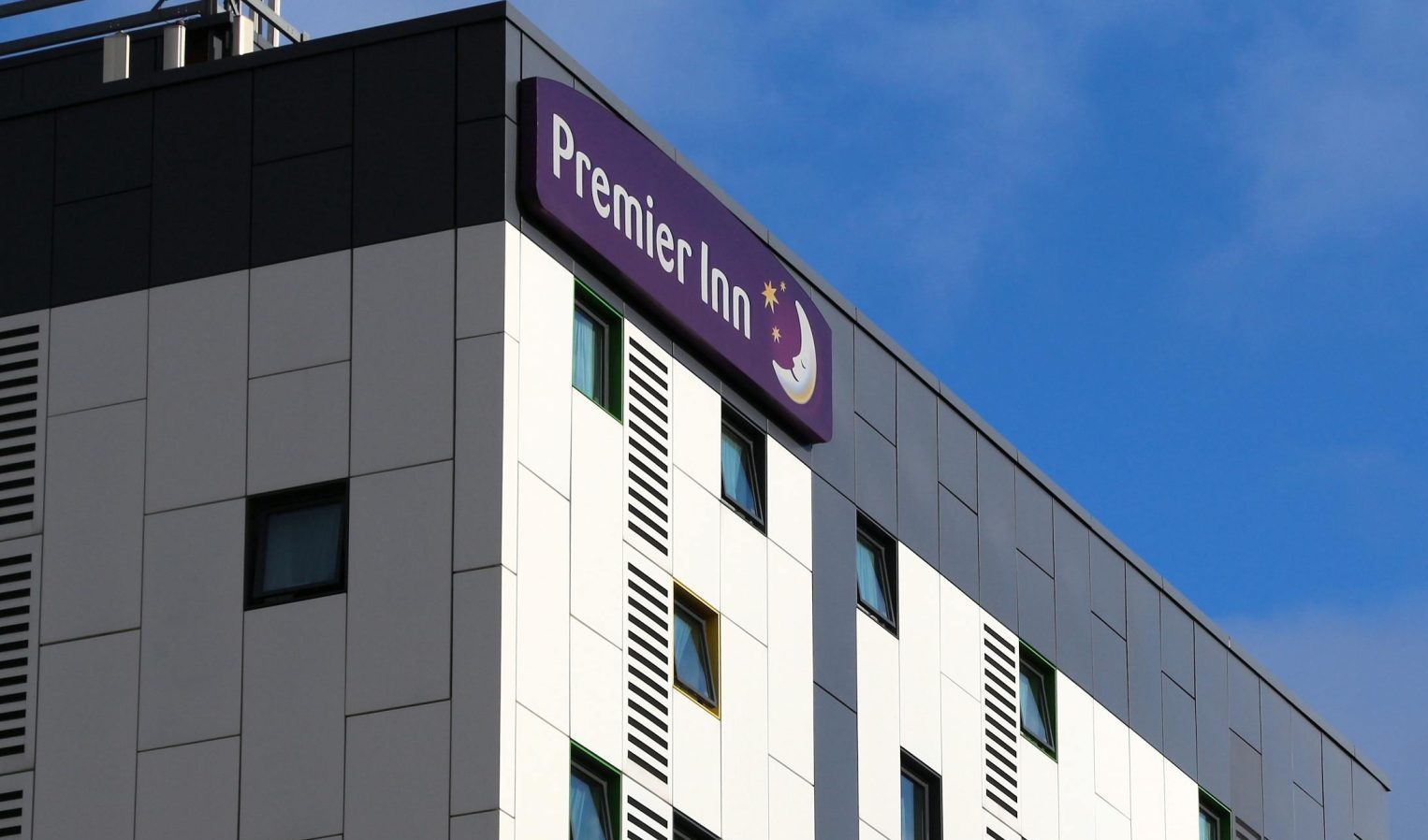 Premier Inn hotel exterior showing multi-storey building with branded signage against a blue sky